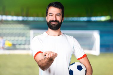 Bir şey bir futbol sahası üzerinde tutan bir futbol topu futbol oyuncu