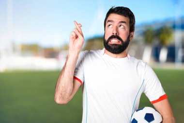 Bir futbol topu futbol sahasında geçiş parmaklarıyla sahip futbol oyuncu