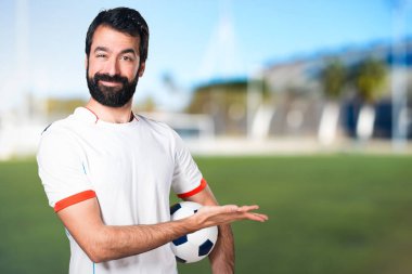 Bir şey bir futbol sahasında sunan bir futbol topu futbol oyuncu