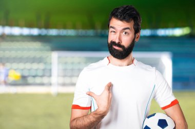 Bir futbol sahası üzerinde bir futbol topu yapma sürpriz jest sahip futbol oyuncu