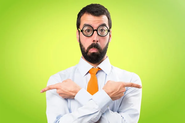 Zabawny Człowiek Okularach Wskazując Przykanalików Mając Wątpliwości Tle Kolorowe — Zdjęcie stockowe