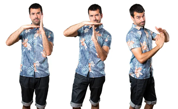 時間をジェスチャーを作る花シャツでハンサムな男の設定します — ストック写真