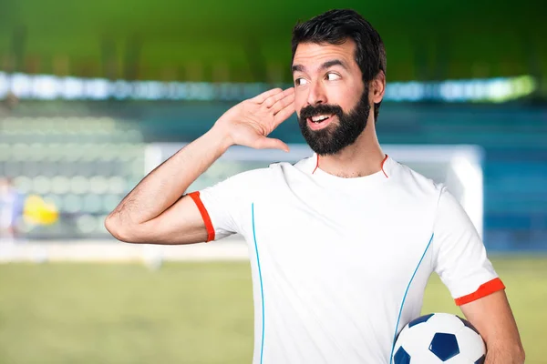 Giocatore Calcio Possesso Pallone Calcio Ascoltando Qualcosa Campo Calcio — Foto Stock