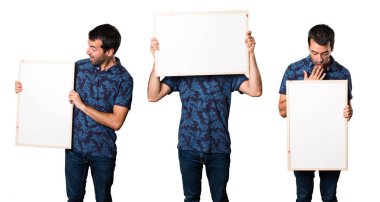 Esmer adam boş bir afiş tutarak kümesi