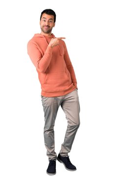 Adam tam vücut içinde parmak tarafına işaret ve bir ürün yalıtılmış beyaz arka plan üzerinde sunma pembe bir kazak