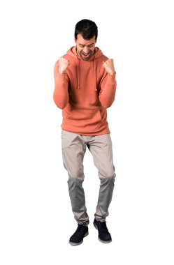 Beyaz arka plan tam gövdesinde adam zafer ve mutlu bir ödül olarak kazandığı için kutlayan pembe bir kazak izole