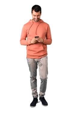 Adam tam vücut içinde bir ileti veya mobil ile e-posta gönderme pembe bir kazak beyaz arka plan izole. Mimari tasarımlarında kullanım için idealdir