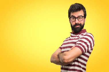 Kollarını ile gözlüklü adam renkli arka plan üzerinde çarpı işareti