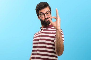 Renkli arka plan üzerinde oturum tamam yapma gözlüklü adam