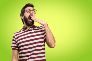 Renkli arka plan üzerinde esneme gözlüklü adam