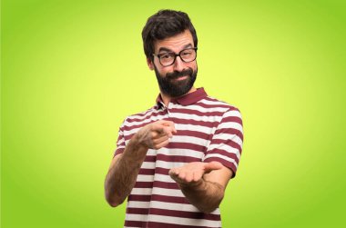 Bir şey renkli arka plan üzerinde tutan gözlüklü adam