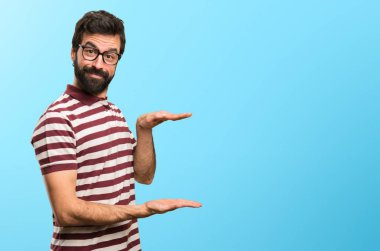 Bir şey renkli arka plan üzerinde tutan gözlüklü adam