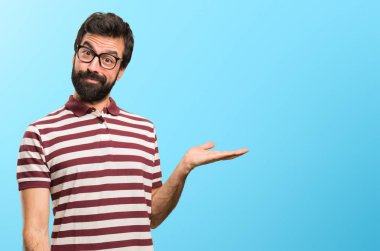 Bir şey renkli arka plan üzerinde tutan gözlüklü adam