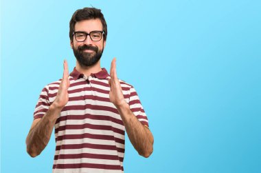 Bir şey renkli arka plan üzerinde tutan gözlüklü adam