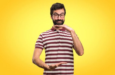 Bir şey renkli arka plan üzerinde tutan gözlüklü adam