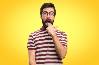 Renkli arka plan üzerinde kusma jest yapma gözlüklü adam