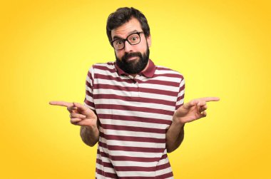 Renkli arka plan üzerinde şüpheleri Laterallerin işaret eden gözlüklü adam