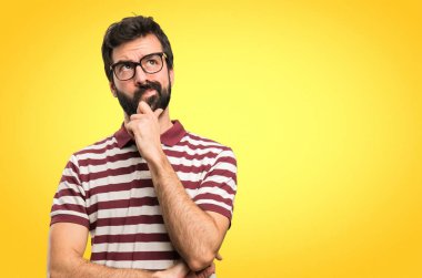 Renkli arka plan üzerinde düşünme gözlüklü adam