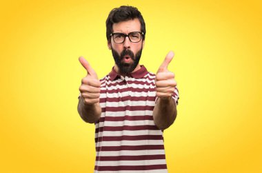 Renkli arka plan üzerinde başparmak ile gözlüklü adam