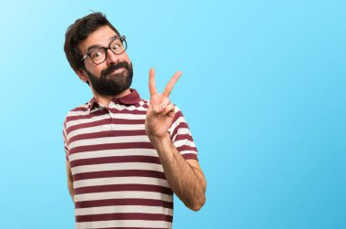 Zafer yapma gözlüklü adam jest renkli arka plan üzerinde