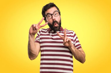 Zafer yapma gözlüklü adam jest renkli arka plan üzerinde