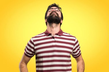 Renkli arka plan üzerinde ararken gözlüklü adam