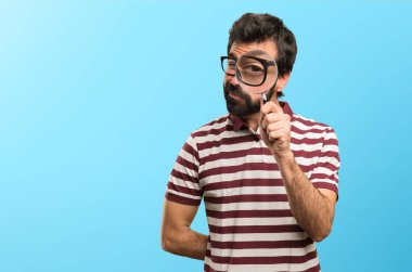 Renkli arka plan üzerinde büyüteç ile gözlüklü adam