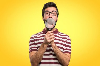 Renkli arka plan üzerinde büyüteç ile gözlüklü adam