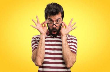 Şaşırmış adam gözlüklü bir şey renkli arka plan üzerinde gösterilen