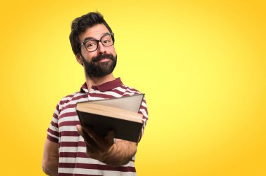 Mutlu adam gözlüklü renkli arka plan ile ilgili bir kitap okuma