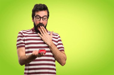 Gözlüklü bir araba renkli arka plan üzerinde tutarak şaşırmış adam