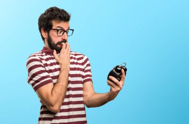 Vintage saat renkli arka plan üzerinde tutarak gözlüklü adam