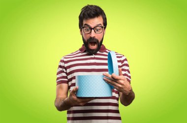 Bir hediye renkli arka plan üzerinde tutarak gözlüklü adam