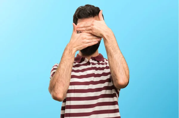 Man with glasses covering his face on colorful background