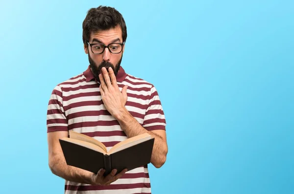 Surprised Man with glasses reading a book on colorful background