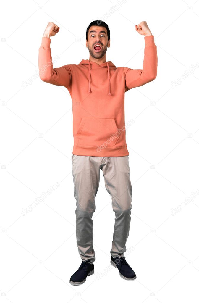 Full body of Man in a pink sweatshirt celebrating a victory and happy for having won a prize on isolated white background