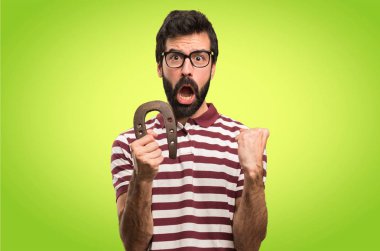 Renkli arka plan üzerinde at nalı ile gözlüklü adam