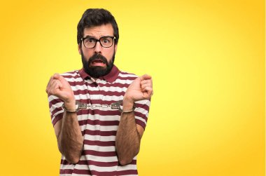 Renkli arka plan üzerinde kelepçe ile gözlüklü adam