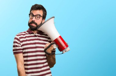 Gözlüklü bir megafon renkli arka plan üzerinde tutan adam