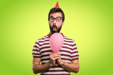 Bir balon renkli arka plan üzerinde tutarak gözlüklü adam