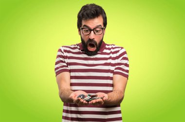 Renkli arka plan üzerinde poker fişleri tutan gözlüklü şaşırmış adam