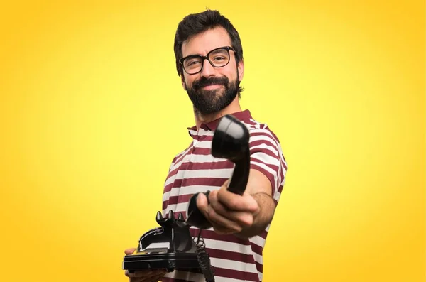 Happy Man with glasses talking to vintage phone on colorful background