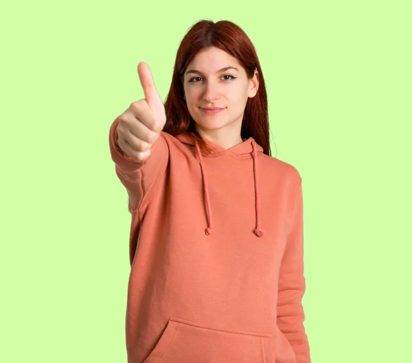 Молодая Рыжая Девушка Розовой Толстовке Показывает Большой Палец Вверх Жестом — стоковое фото
