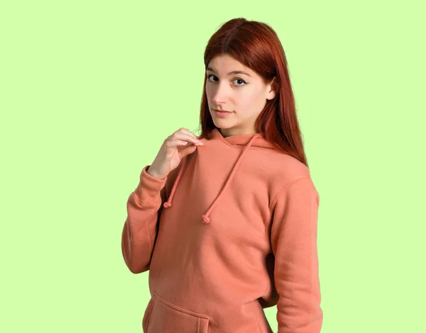 誇りと自己満足のピンクのトレーナーと若い赤毛の女の子は自分の緑の背景の概念を愛する — ストック写真