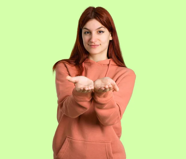 Junge Rothaarige Mädchen Mit Rosa Sweatshirt Hält Kopierraum Imaginären Auf — Stockfoto