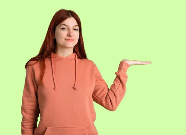 Junge Rothaarige Mädchen Mit Rosa Sweatshirt Hält Kopierraum Imaginären Auf — Stockfoto