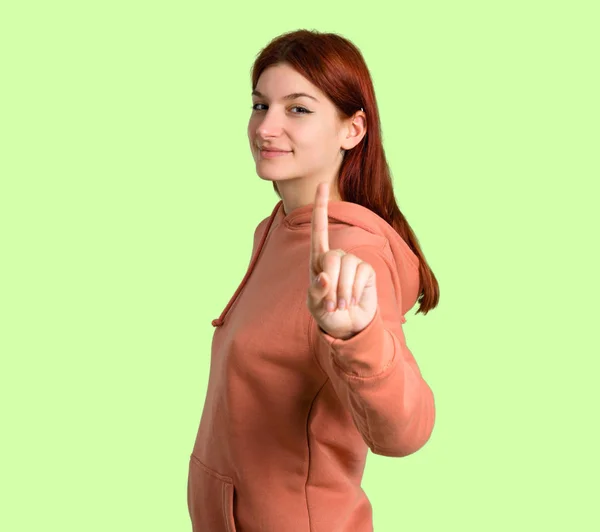 Young Redhead Girl Pink Sweatshirt Showing Lifting Finger Sign Best — Stock Photo, Image