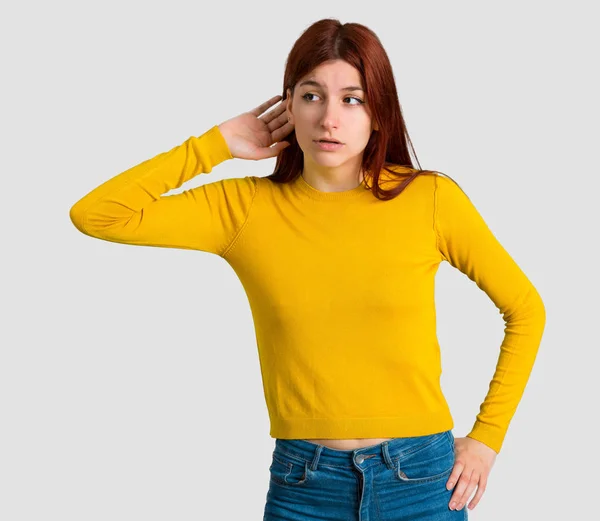 Menina Ruiva Jovem Com Suéter Amarelo Ouvindo Algo Colocando Mão — Fotografia de Stock