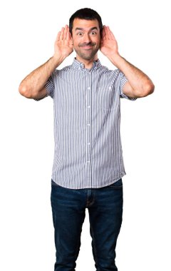 Yakışıklı adam izole beyaz arka planda bir şey dinleme