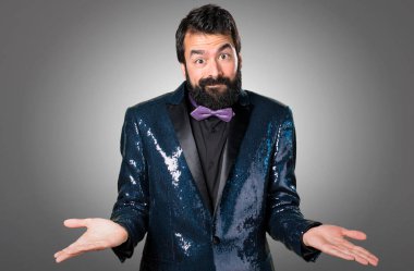 Payet ceket gri arka plan üzerinde önemsiz jest yapma ile yakışıklı adam